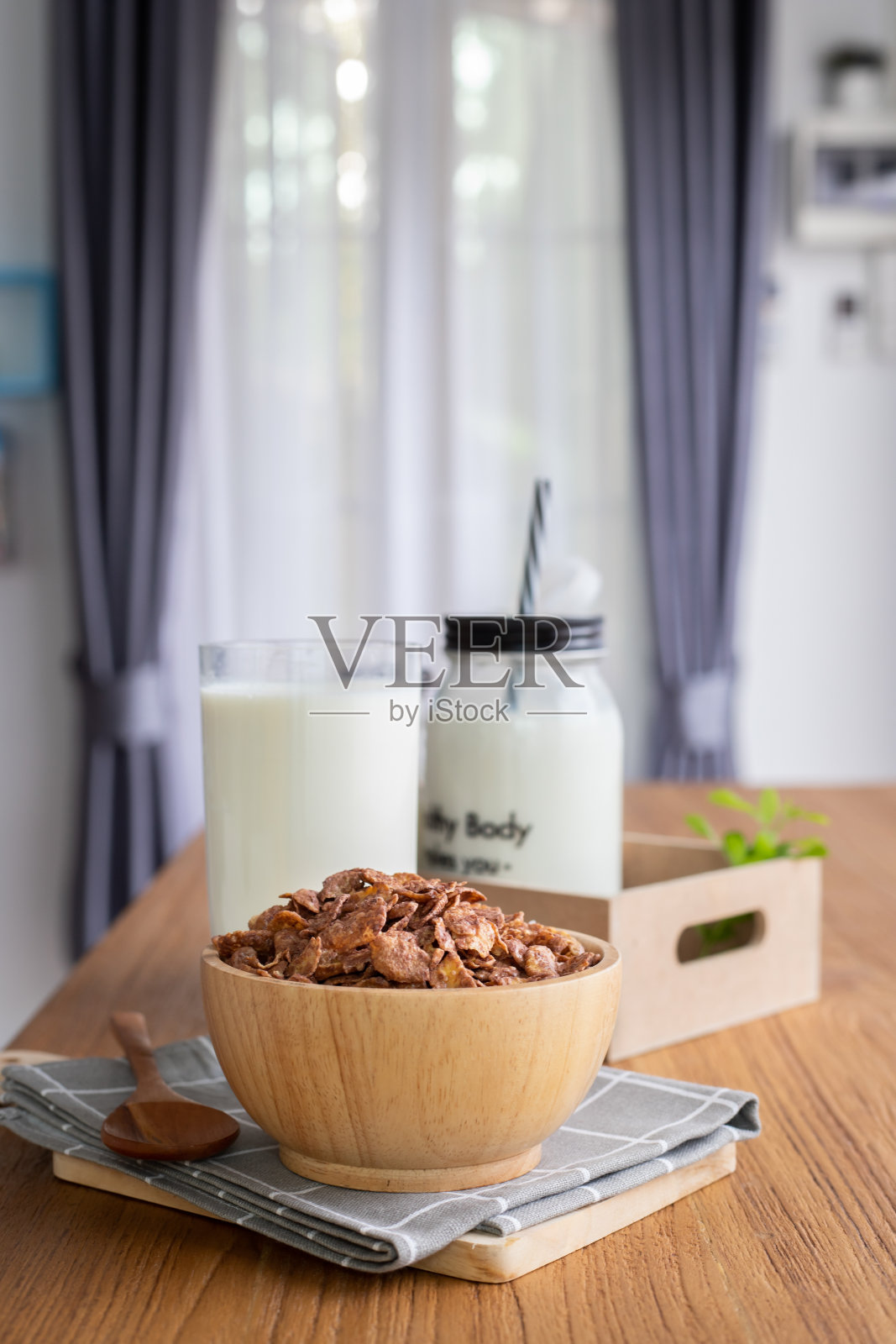 早餐麦片配上一杯牛奶，客厅的木桌上放着一瓶牛奶。照片摄影图片