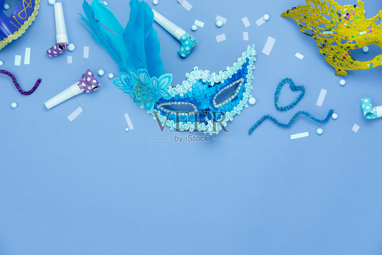桌面俯瞰航拍图像的美丽多彩的狂欢节季节或照片亭prop Mardi Gras背景。在蓝色墙纸上平铺彩色装饰和五彩纸屑。复制空间设计。照片摄影图片