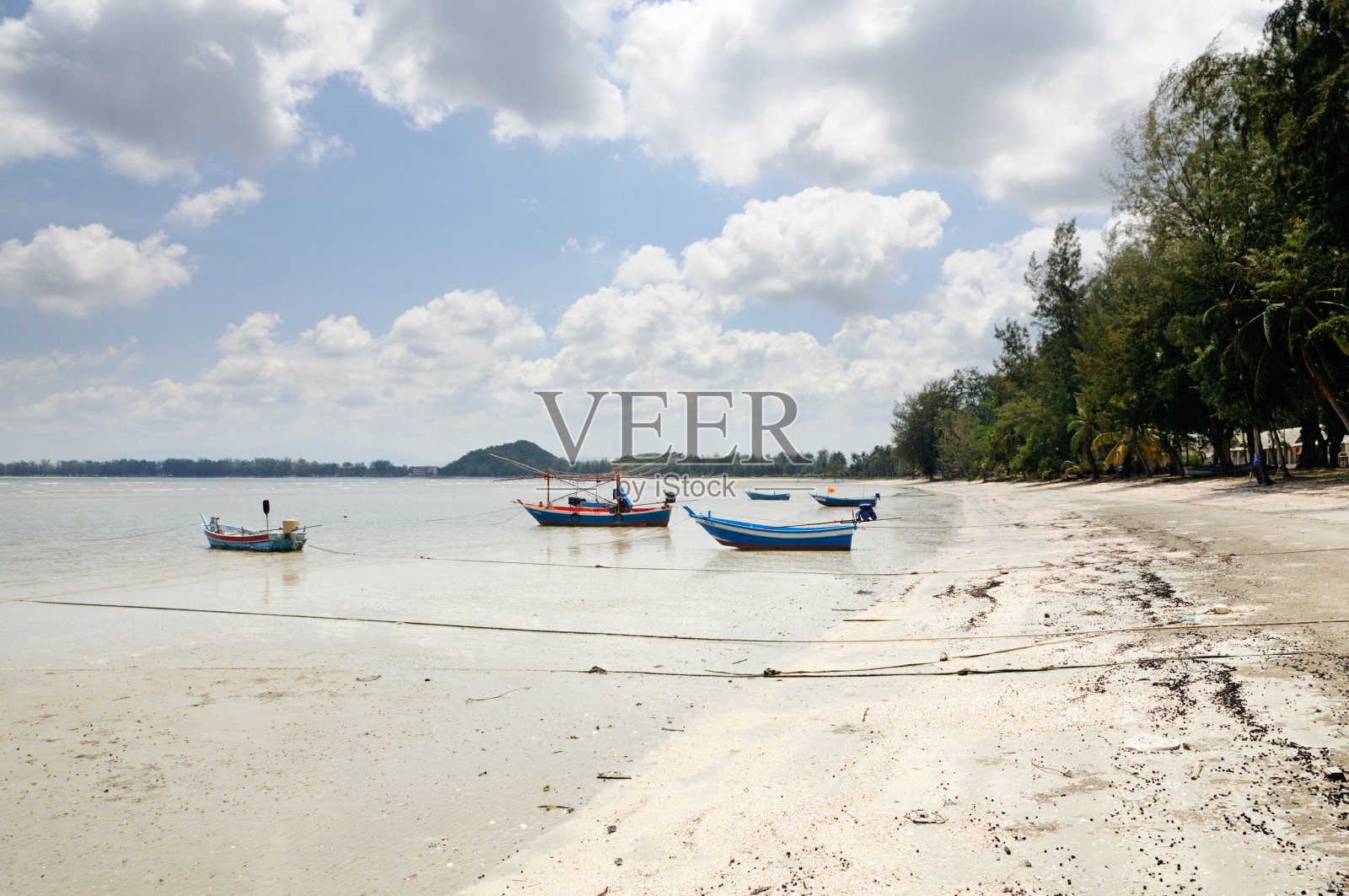 泰国的长尾渔船在退潮期间在昂马瑙湾的沙滩上照片摄影图片