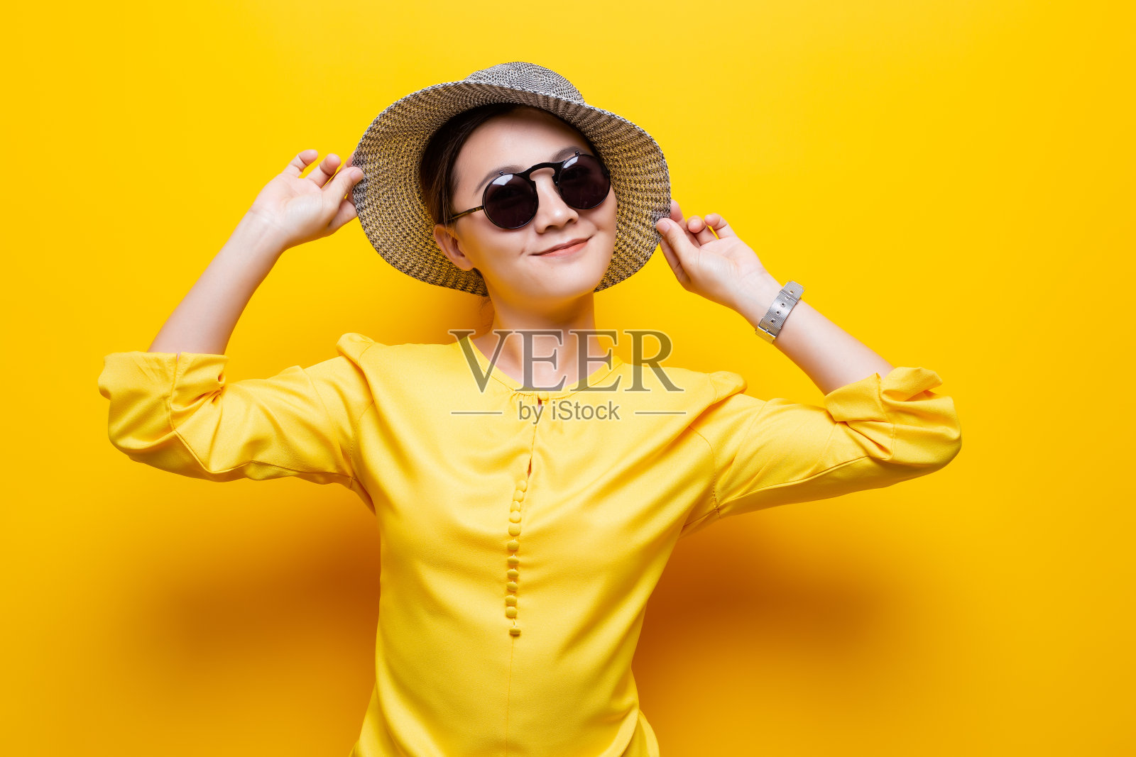肖像女人戴太阳镜和帽子隔离在黄色背景照片摄影图片