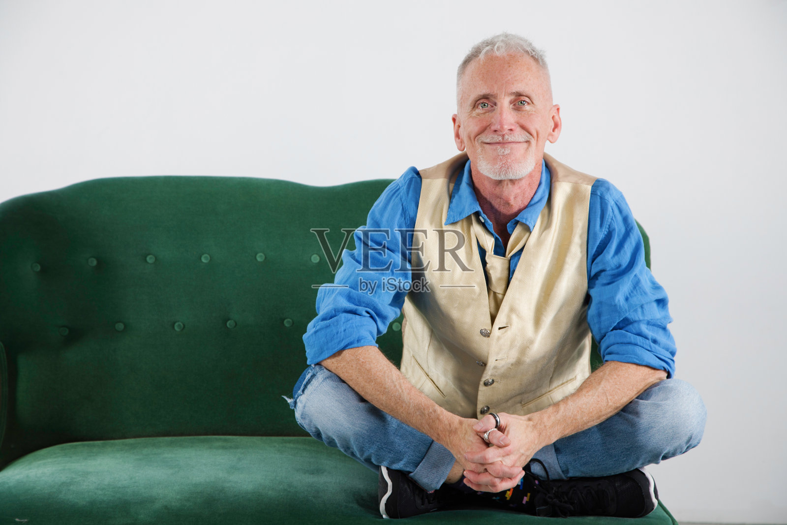 成熟的男人微笑肖像在时尚的衣服肖像在复古的沙发照片摄影图片