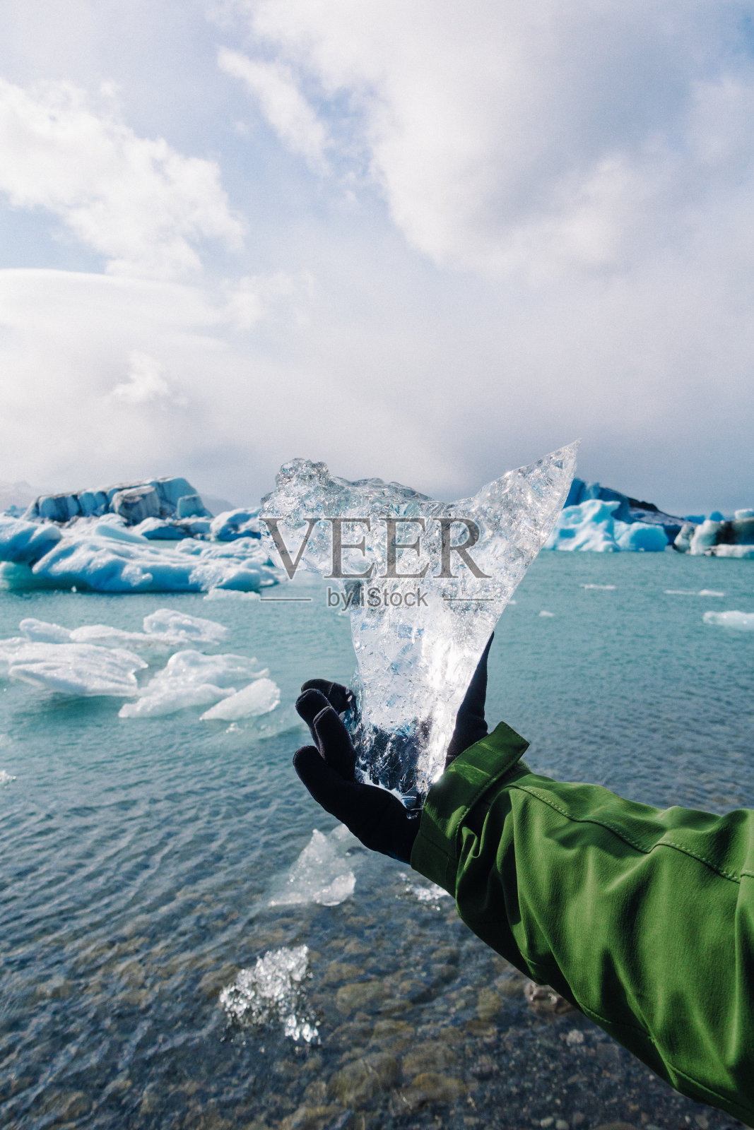 冰岛Jokulsarlon冰川泻湖附近，一名男子手持冰块照片摄影图片