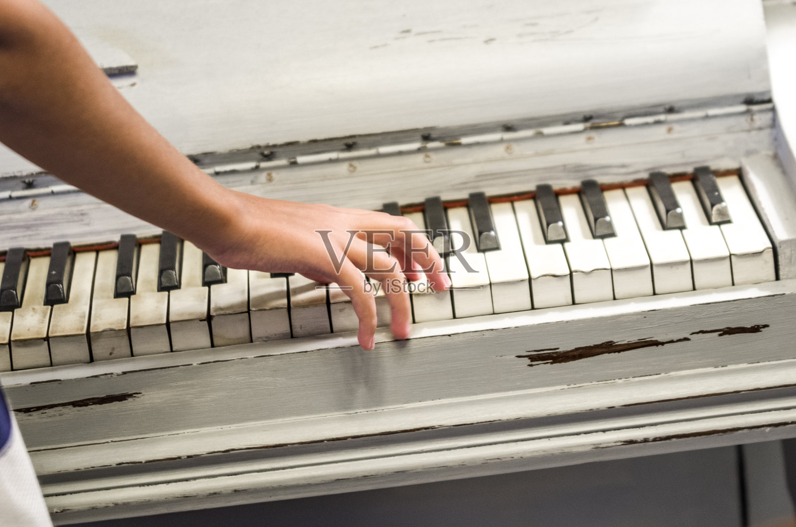 这位年轻的音乐家用双手弹奏着一架旧钢琴照片摄影图片