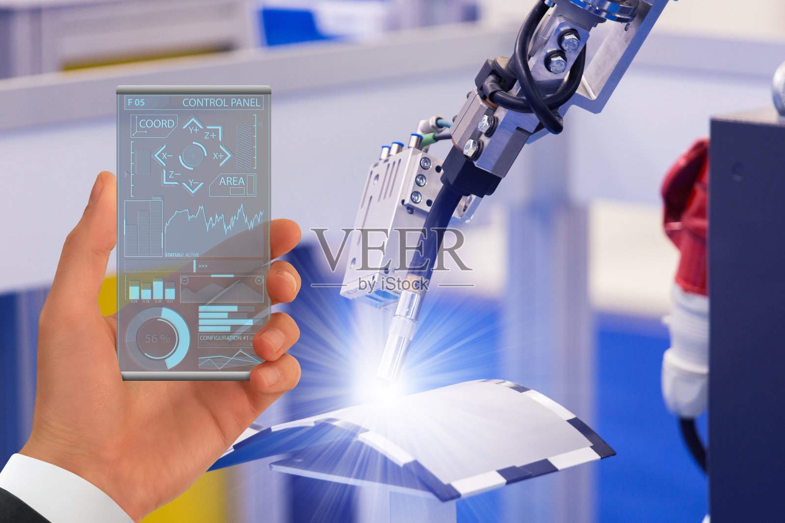 工程师使用未来透明智能手机在智能工厂控制焊接机器人照片摄影图片