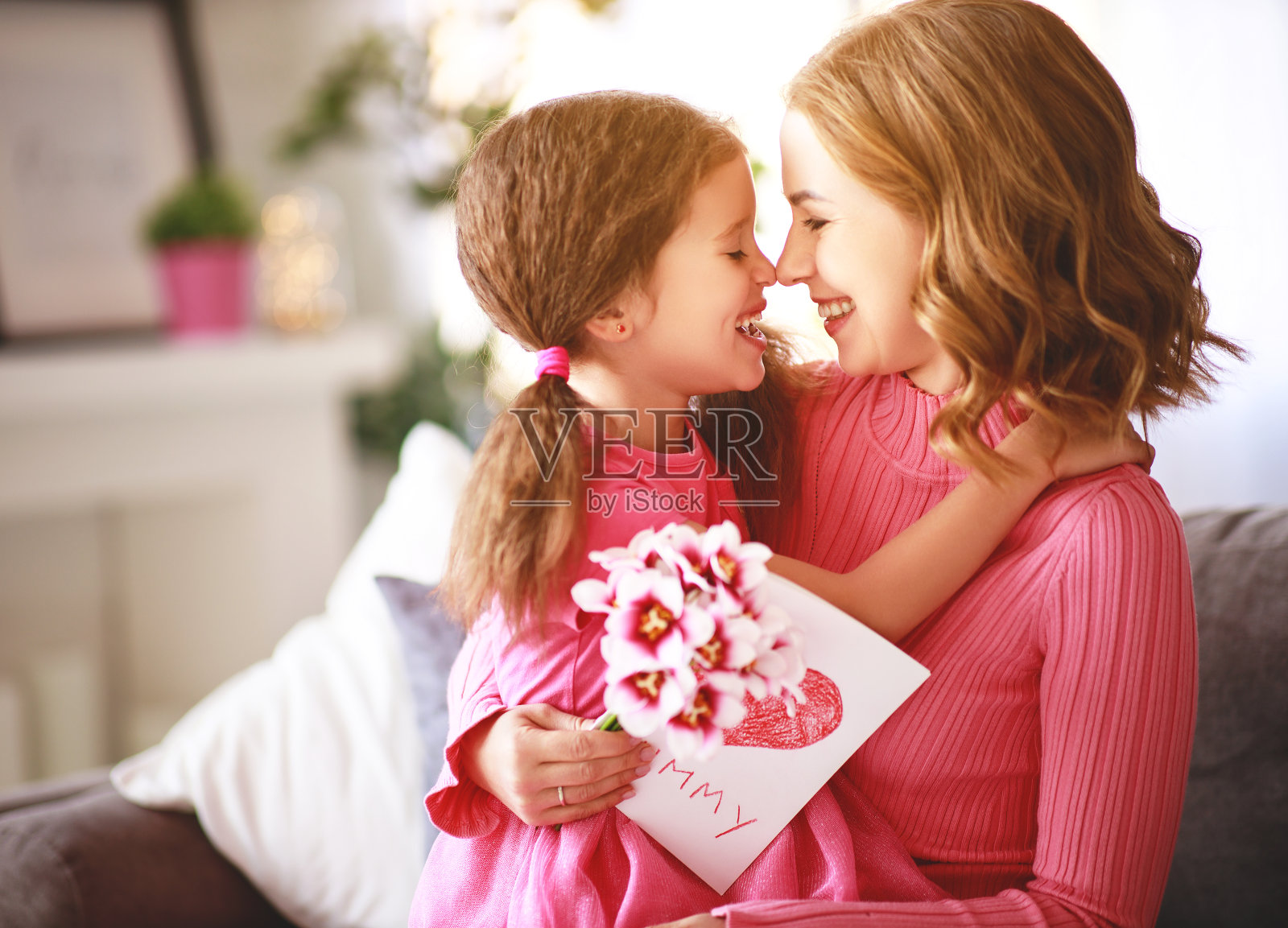 母亲节快乐!女儿送给妈妈一束花和一张明信片照片摄影图片