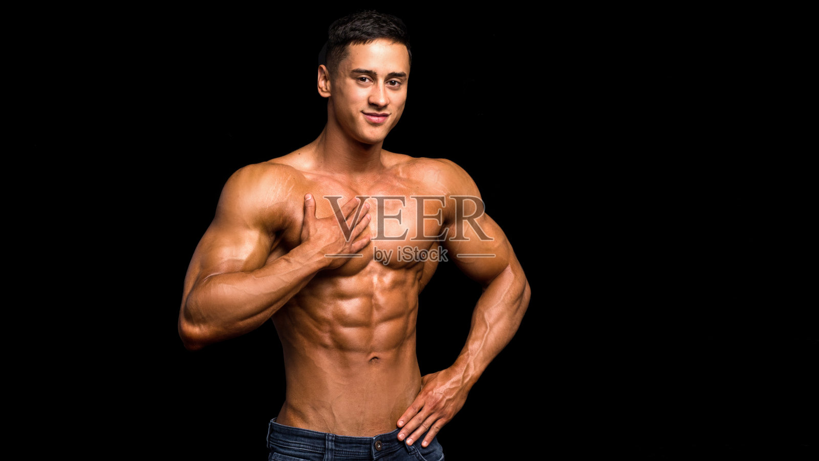 性感的赤膊男子触摸他的肌肉胸部在黑色的背景照片摄影图片