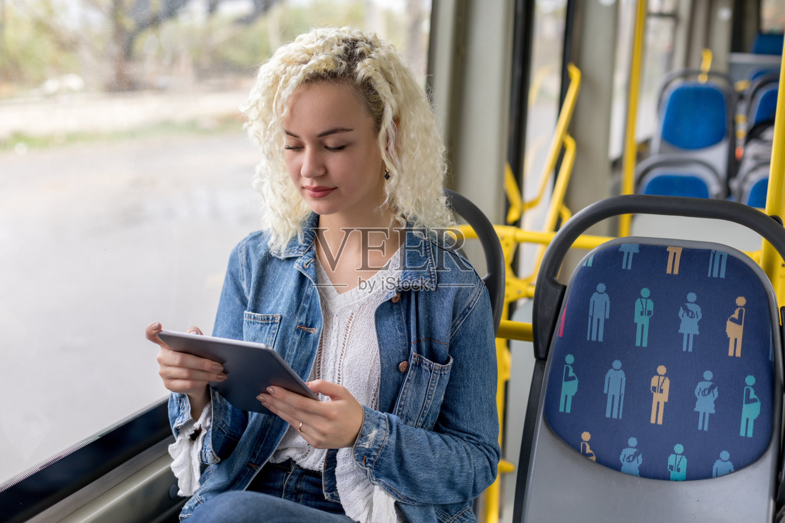 年轻女子在公交车上使用平板电脑照片摄影图片