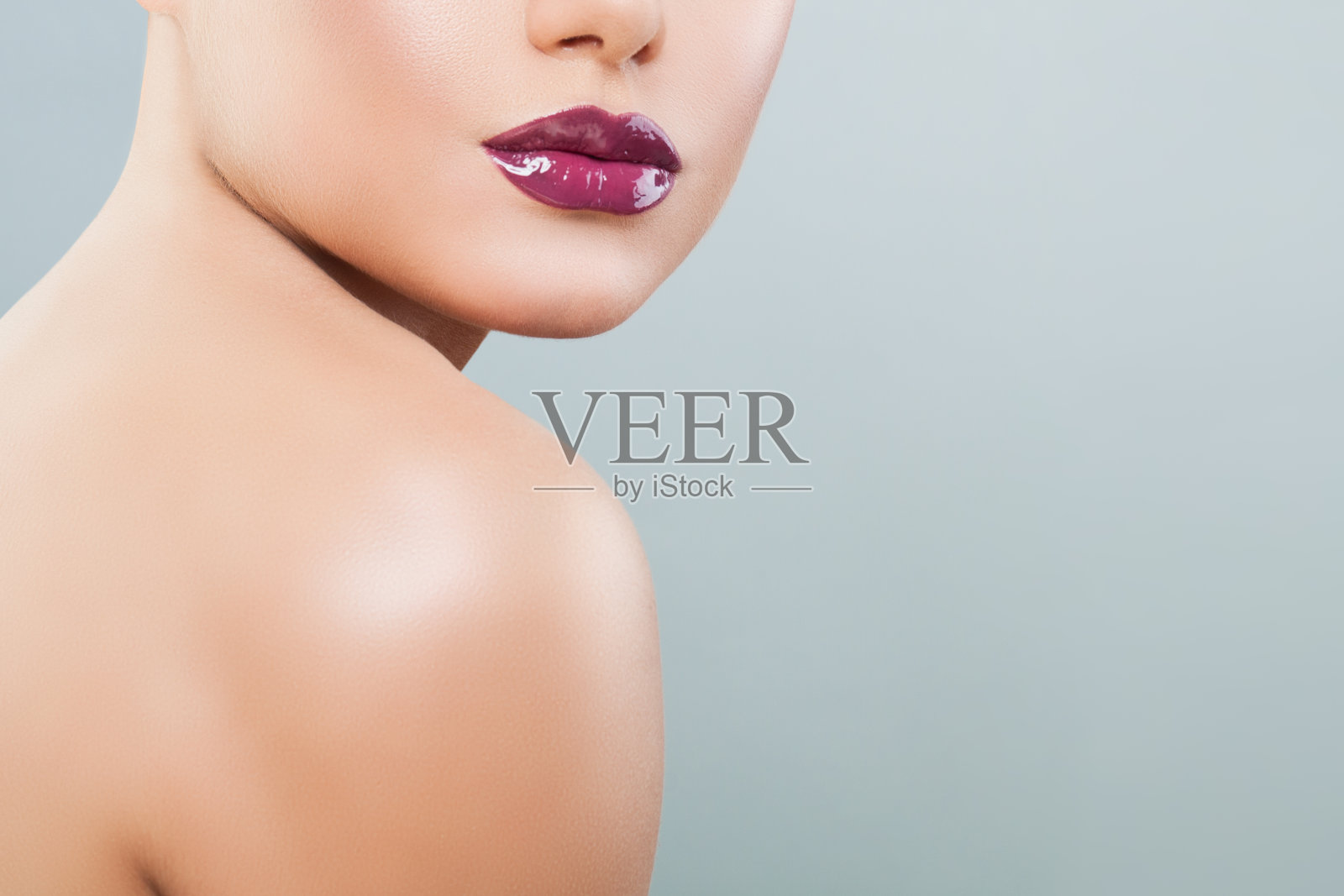 美丽的女人的嘴唇与紫色光泽的口红和唇彩的背景与复制空间照片摄影图片