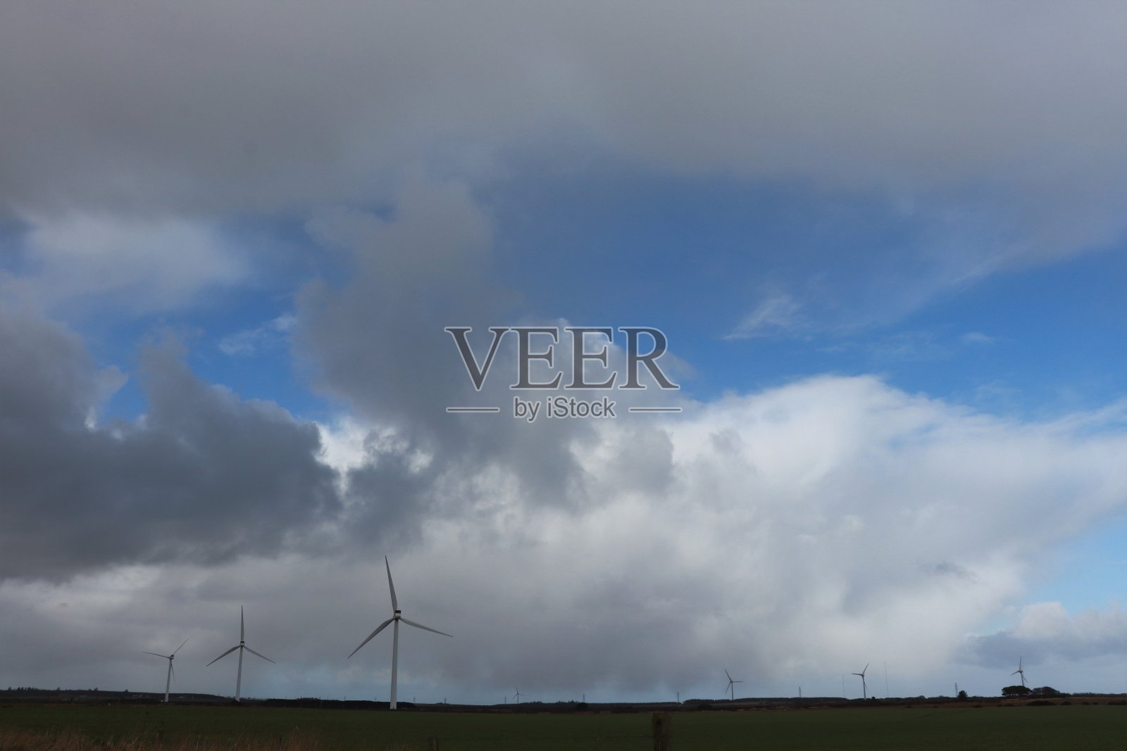 风力涡轮机在田野下戏剧性的天空与云彩照片摄影图片