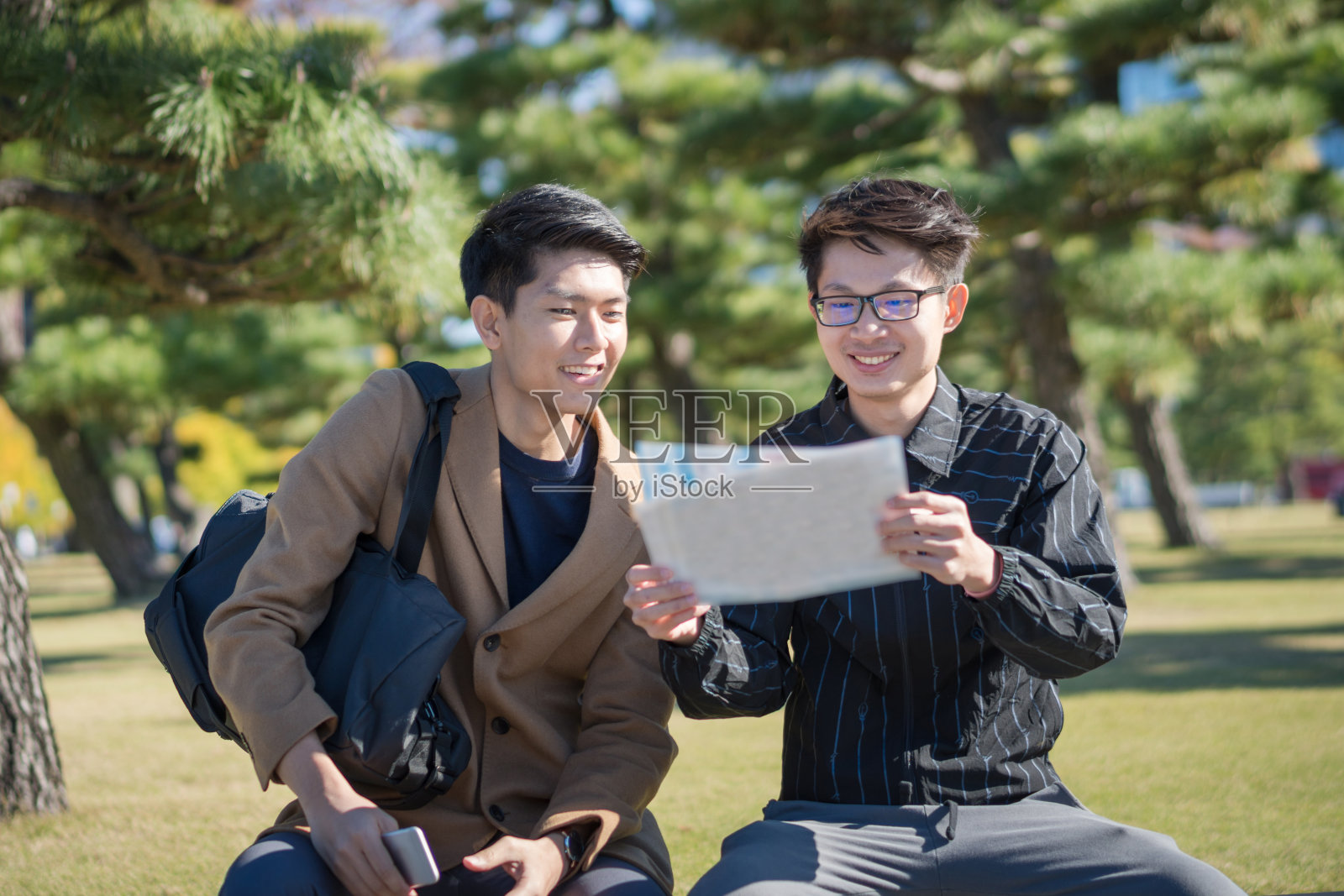 年轻的亚洲男子和日本朋友寻找旅游地点使用手机和花时间在亚洲旅行照片摄影图片