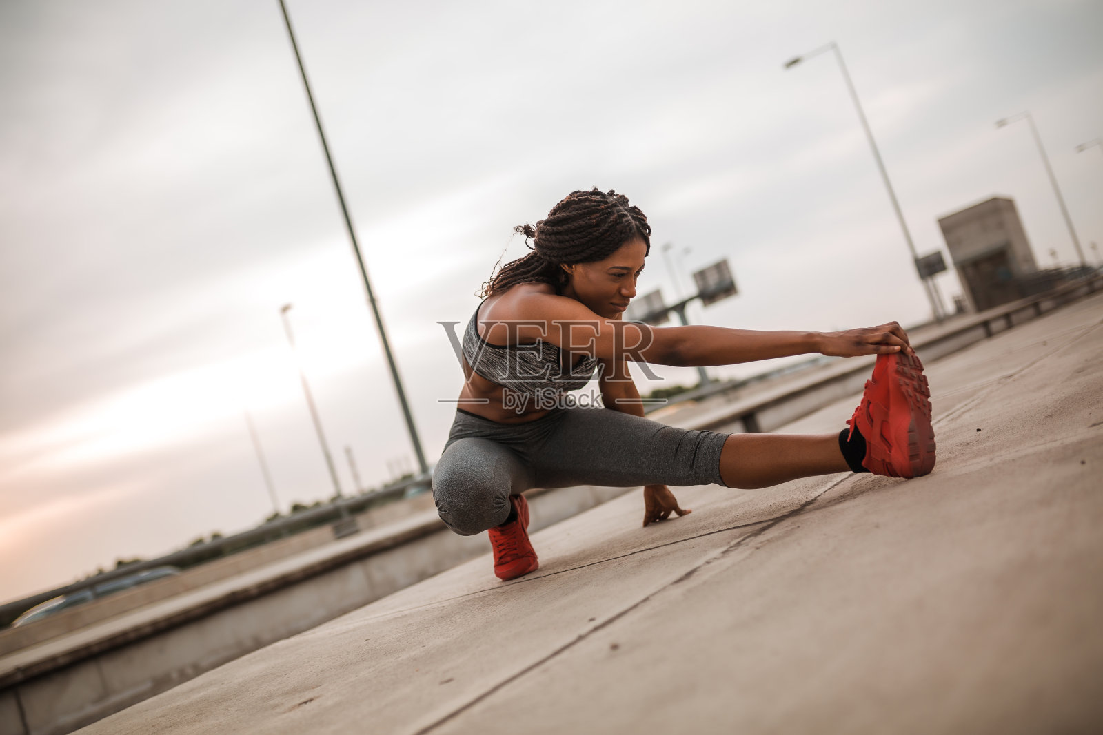 一个非洲裔美国女孩跑步后在街上伸腿照片摄影图片