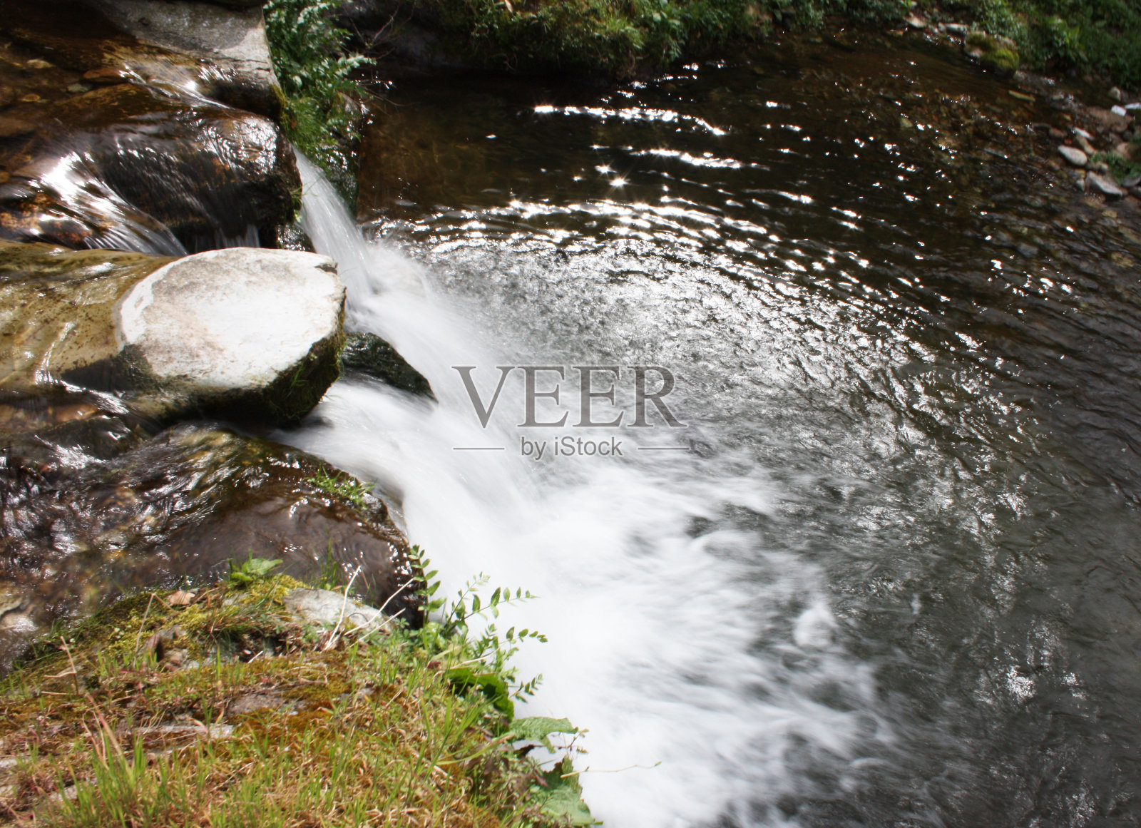 具有丝绸效果的水路。在树木繁茂的平原中央，从瀑布中流过的一条小河照片摄影图片