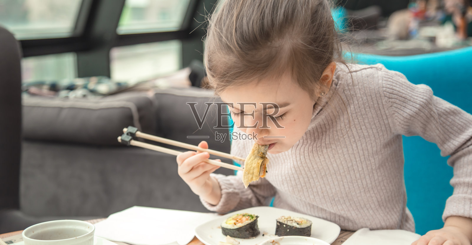 迷人有趣的女孩在餐厅吃寿司照片摄影图片