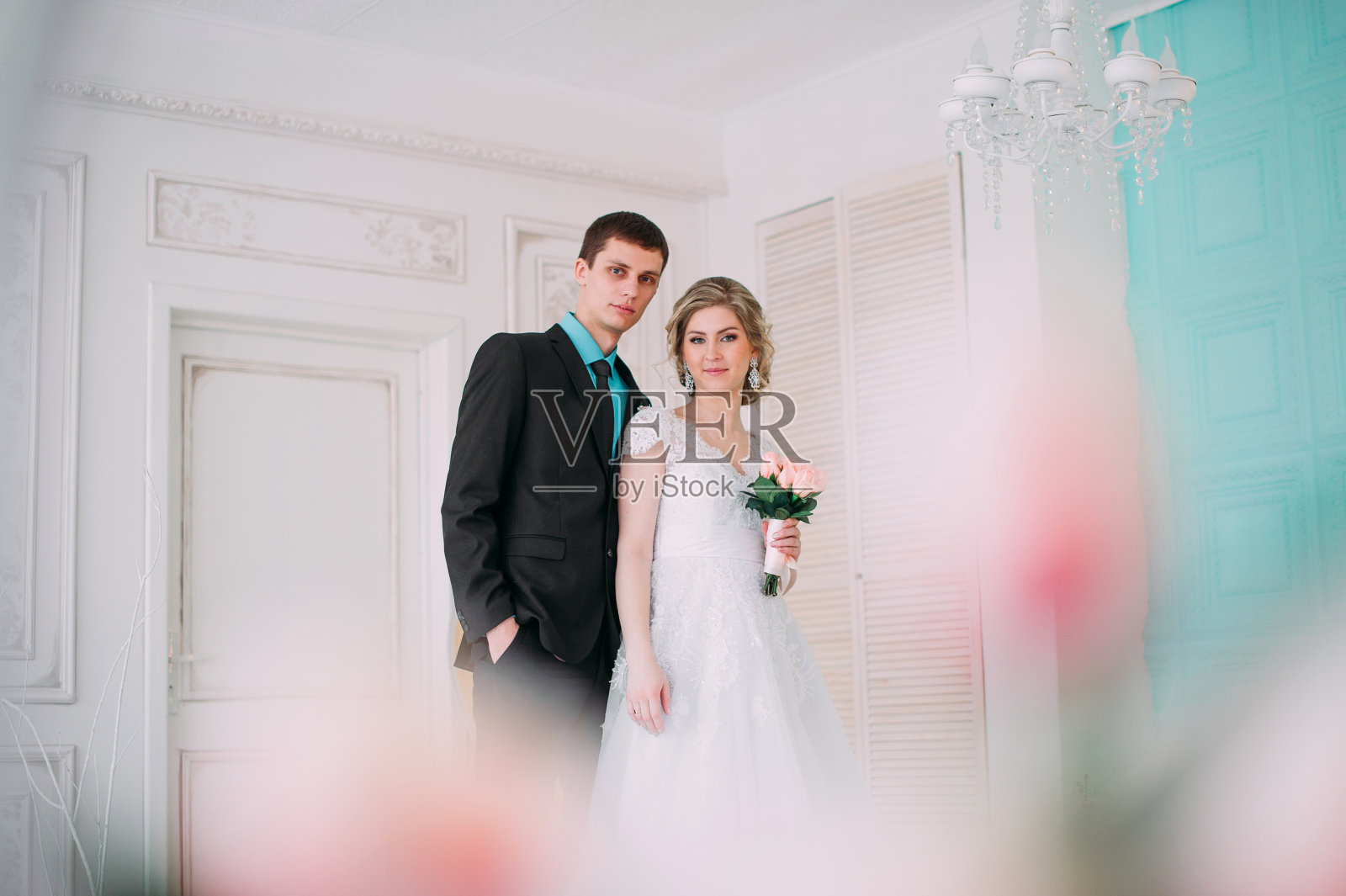 幸福的夫妻。婚礼照片拍摄在白色工作室与婚礼装饰亲吻，拥抱照片摄影图片