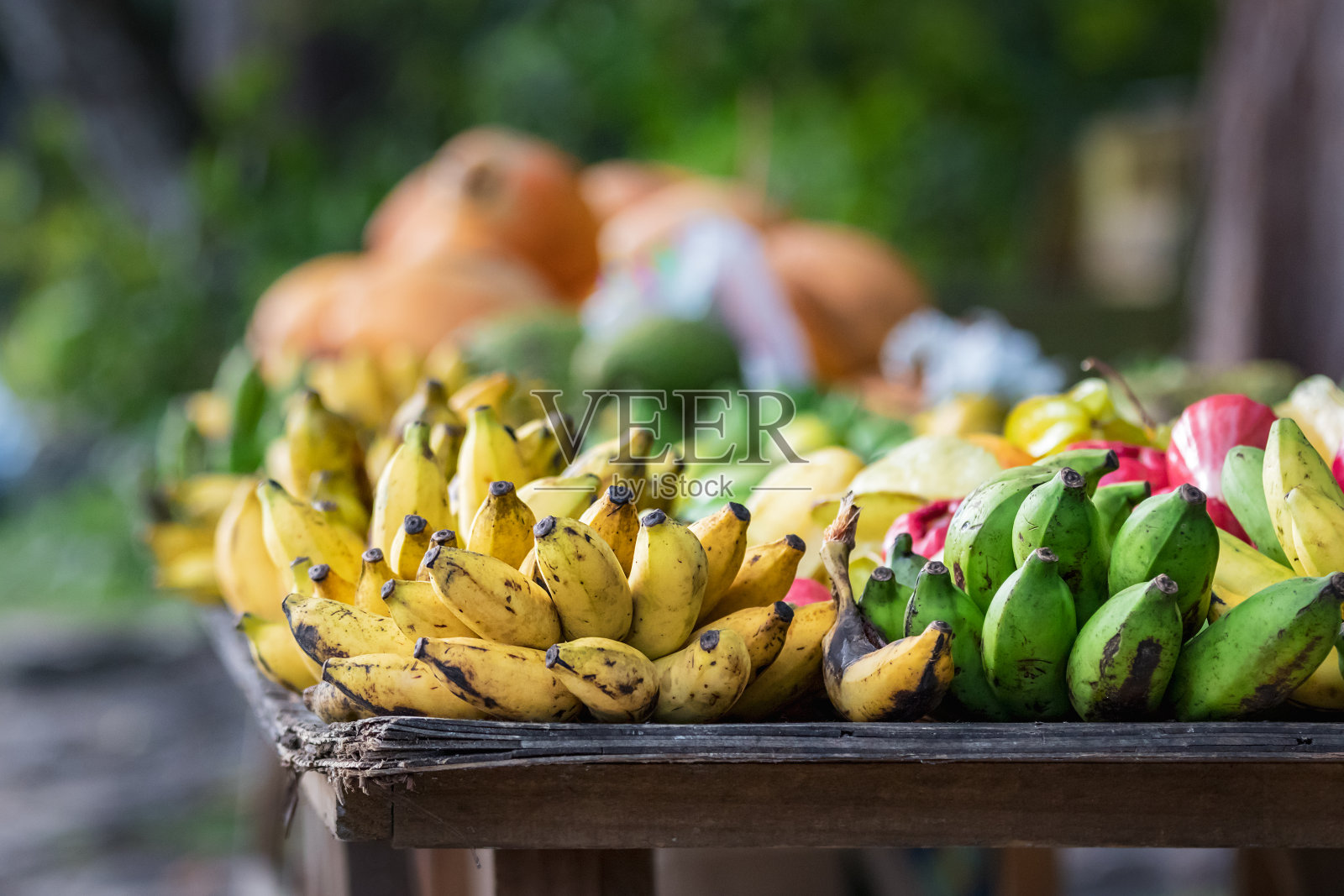 塞舌尔，普拉林大街上的户外木桌上放着香蕉和绿色的芭蕉照片摄影图片