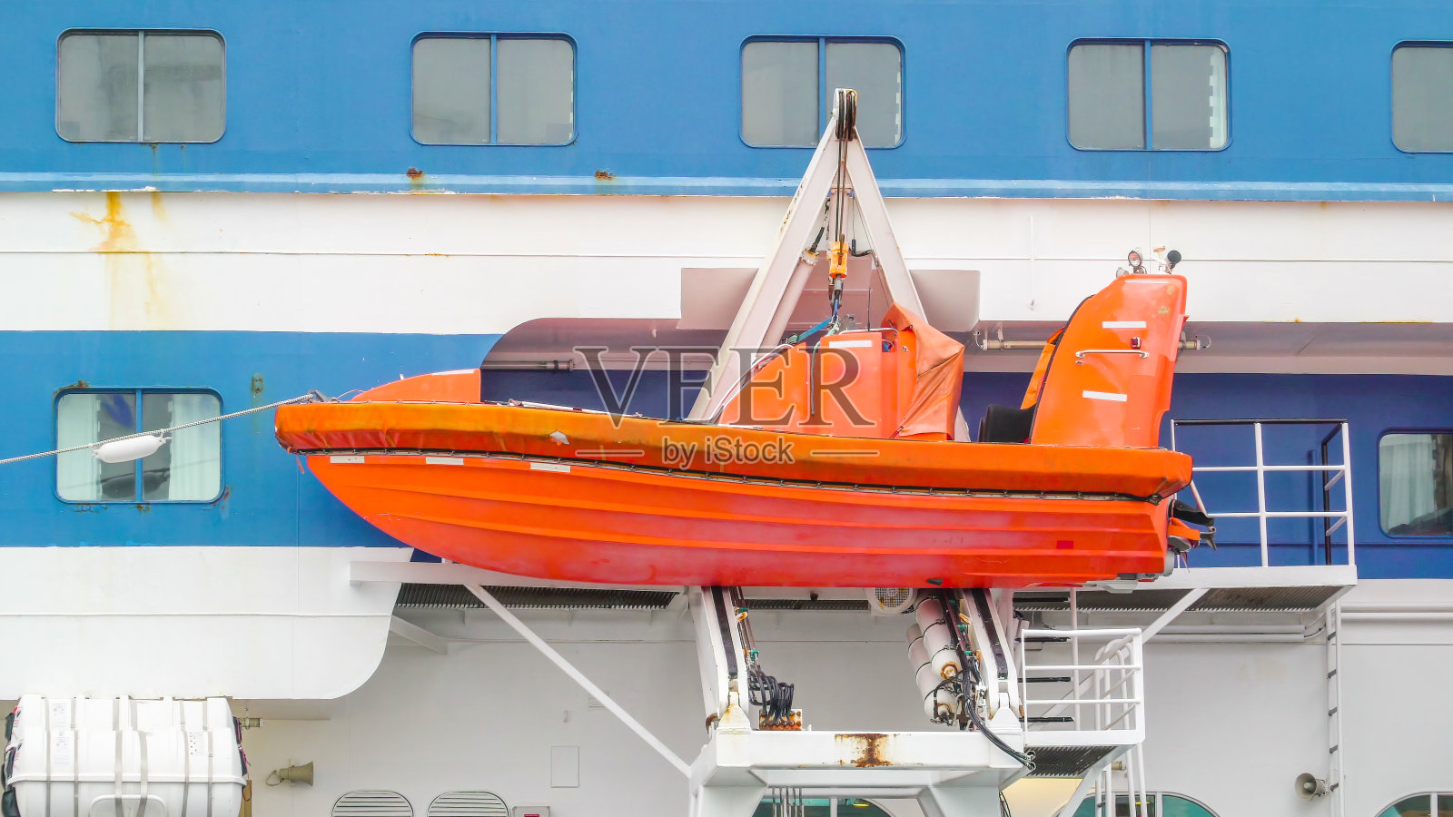 在瑞典斯德哥尔摩，一艘橙色的快艇在游船的一侧照片摄影图片