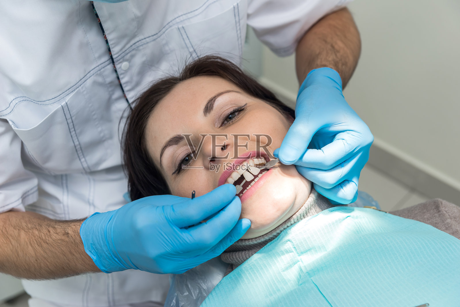 牙医用采样器比较病人的牙齿颜色照片摄影图片