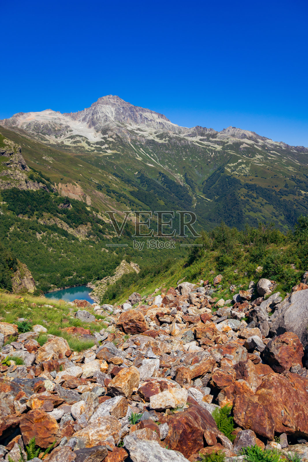 通过巨大的石头通往高山湖的道路的大全景。高加索山脉在一个夏天，晴朗的一天。东白市郊的Tourie湖。照片摄影图片
