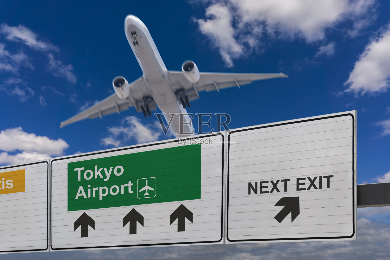 指示东京机场方向的路标和刚起飞的飞机。照片摄影图片