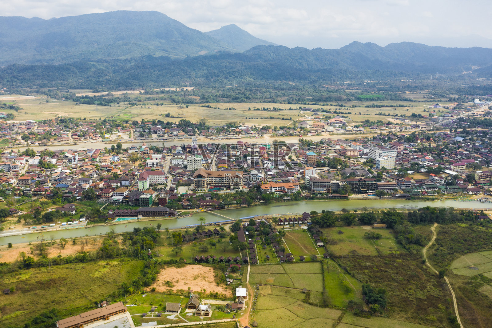 从上面俯瞰，鸟瞰美丽的城市Vang Vieng。万荣(Vang Viang)是老挝万象省的一个旅游小镇，距首都曼谷北部大约4小时的车程。照片摄影图片