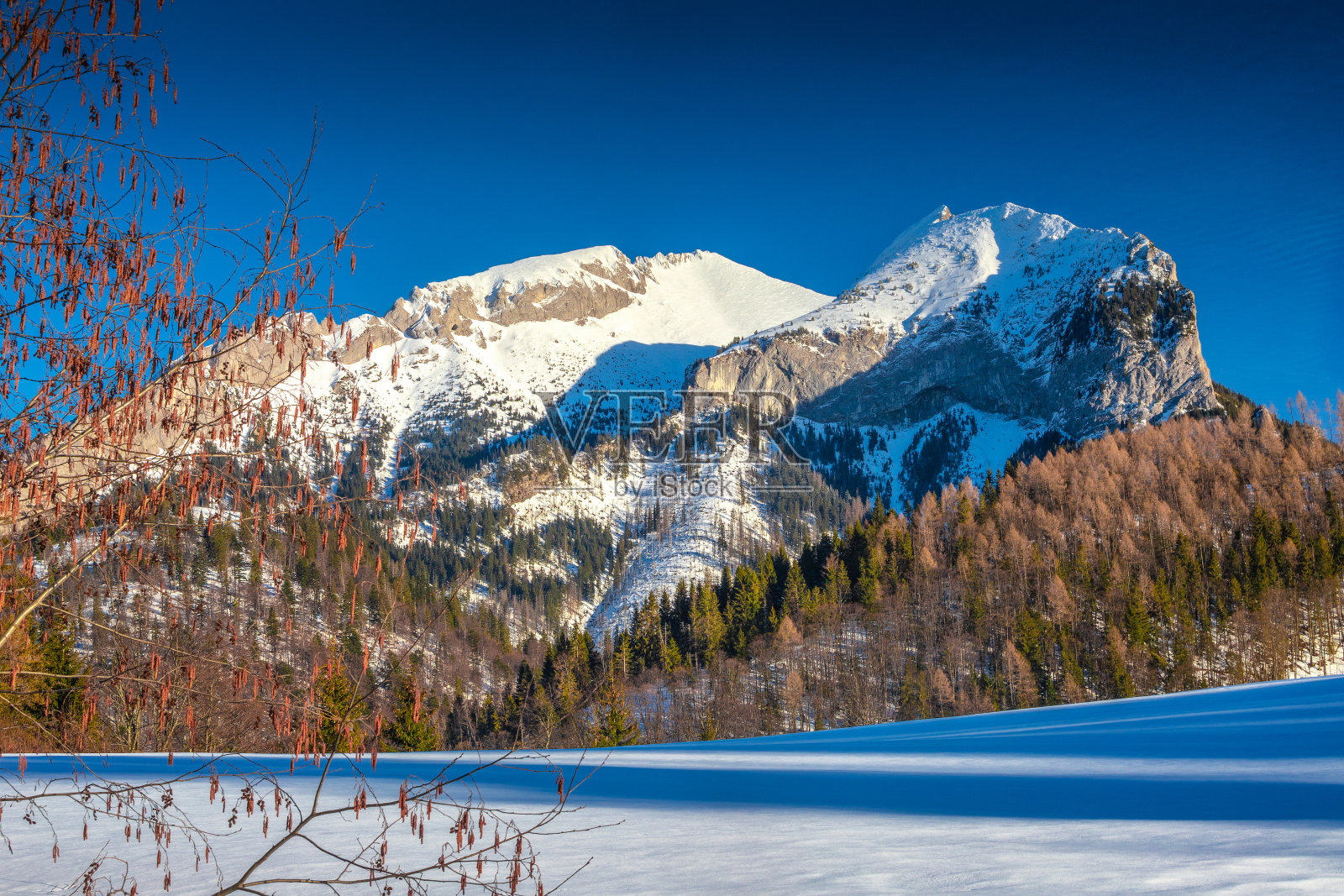 白雪皑皑的冬季景观与山在日落。照片摄影图片