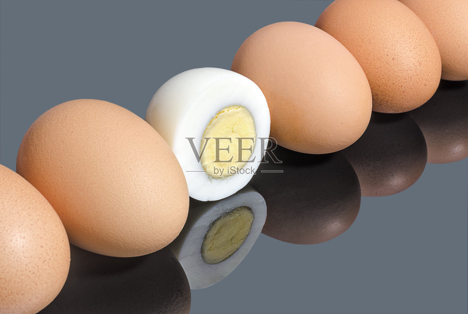 半熟的鸡蛋在一排鸡蛋在灰色的镜子背景照片摄影图片