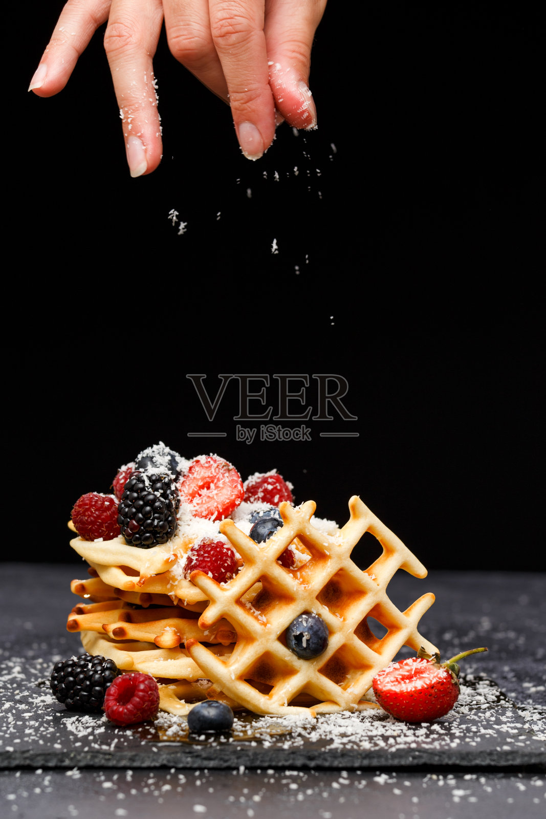 在空白的背景下，在黑板上用覆盆子、草莓和糖粉点缀的维也纳薄饼照片摄影图片