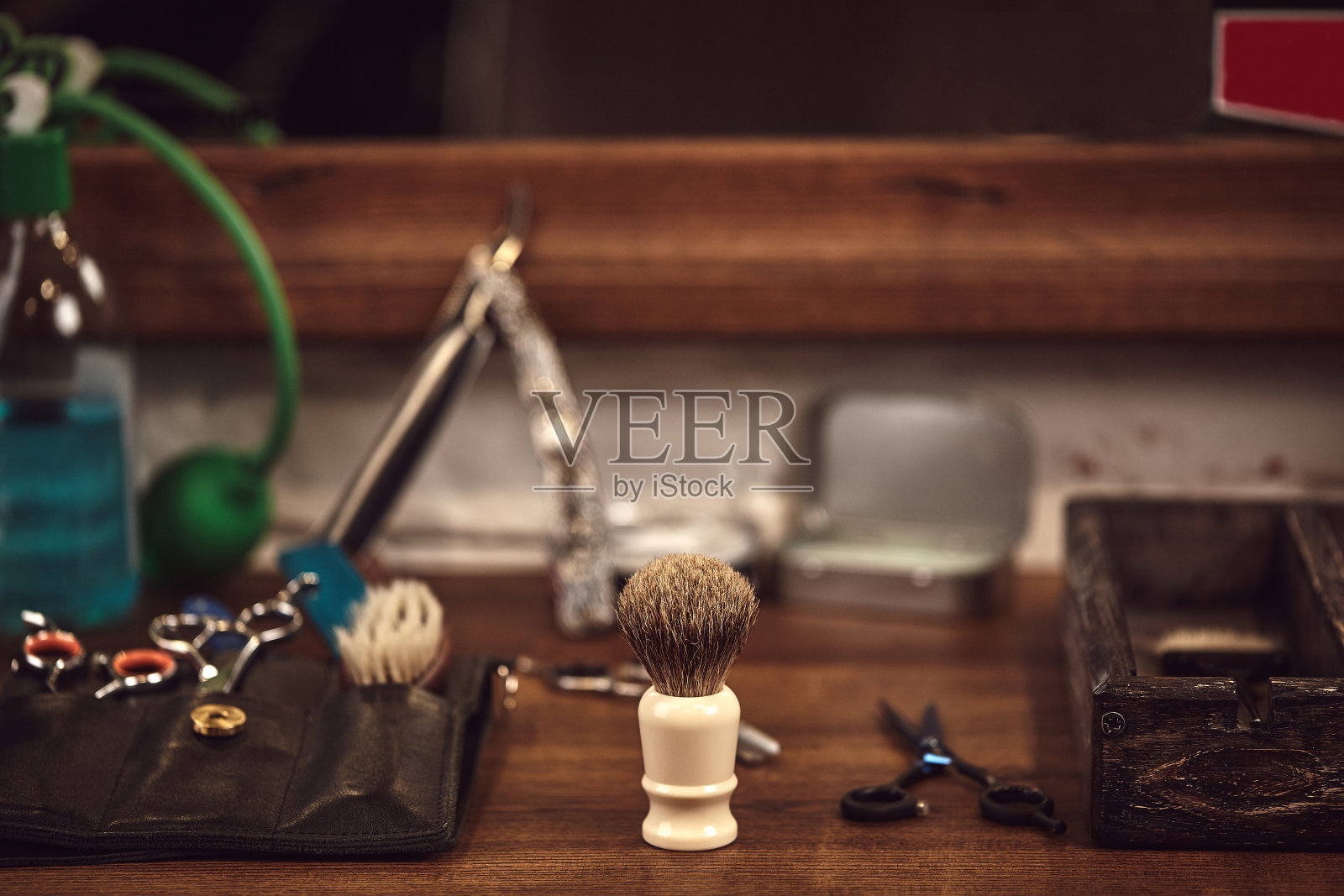棕色木头桌子上放着理发店的工具。桌上有剃须和理发用的配件。照片摄影图片