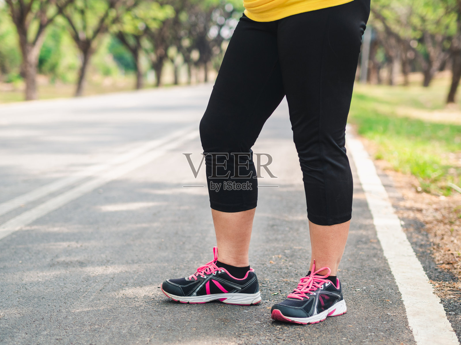 超重的女人在跑步前站在公园里。减肥的概念照片摄影图片