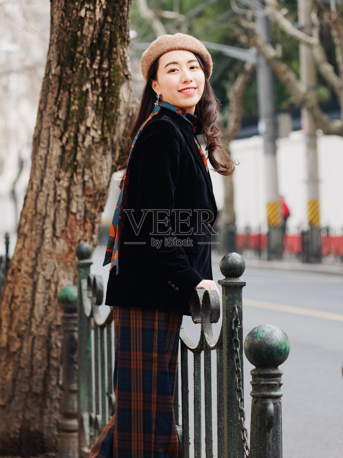 美丽年轻的黑发女人看着和微笑与模糊的街道背景。户外时尚写真魅力中国开朗时尚淑女。情感、人、美、生活理念照片摄影图片