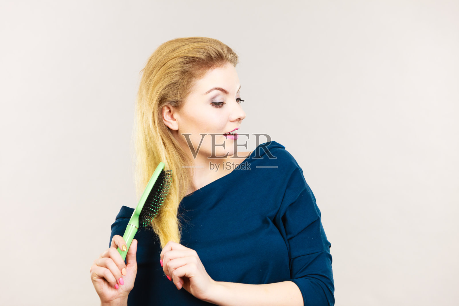 一个女人正在梳理她的金色长发照片摄影图片