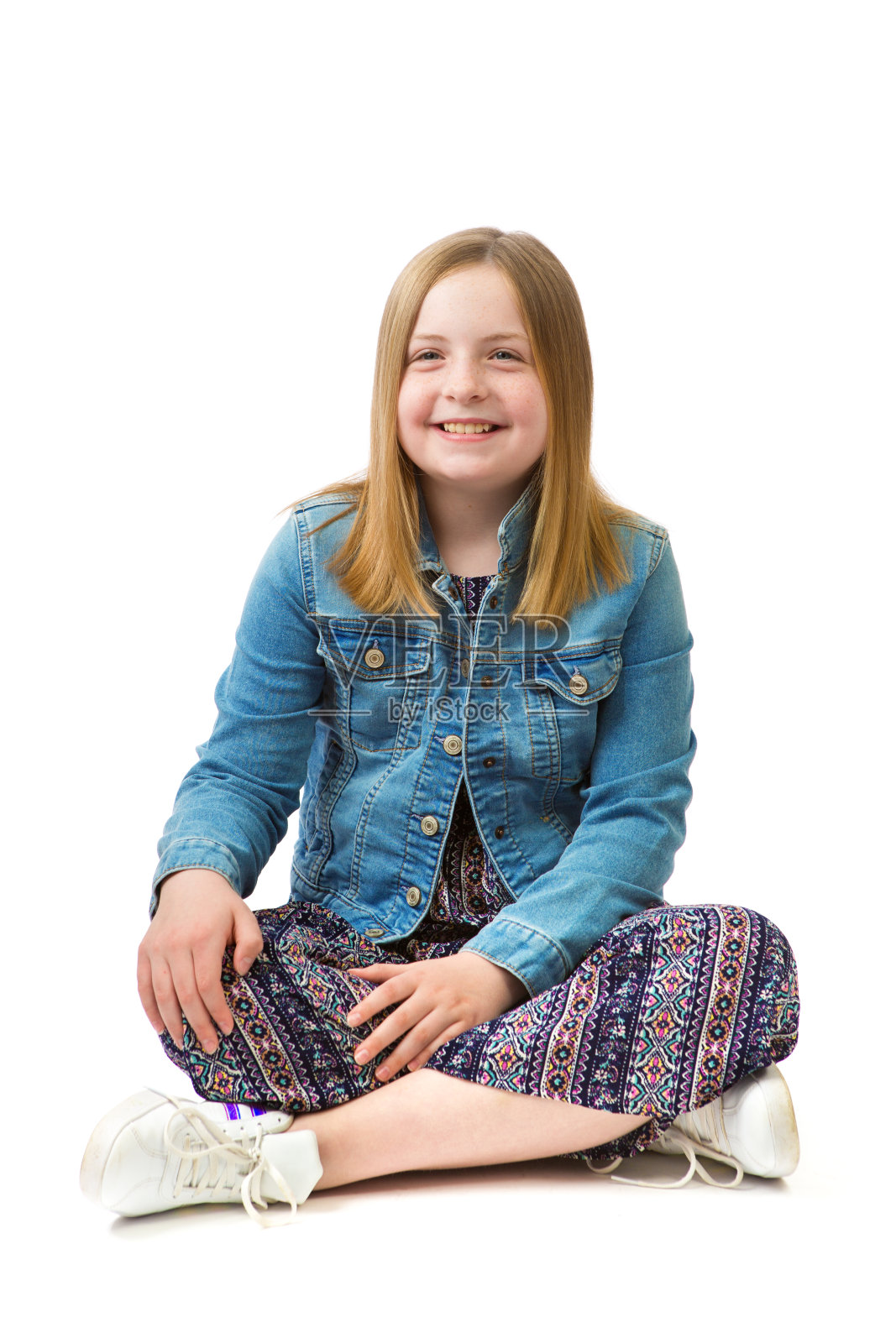 一个年轻的少女坐在地板上白色背景的全长肖像照片摄影图片