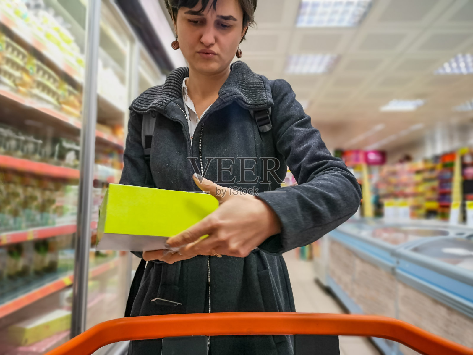 年轻女子在超市购物与购物车阅读产品包装上的标签照片摄影图片