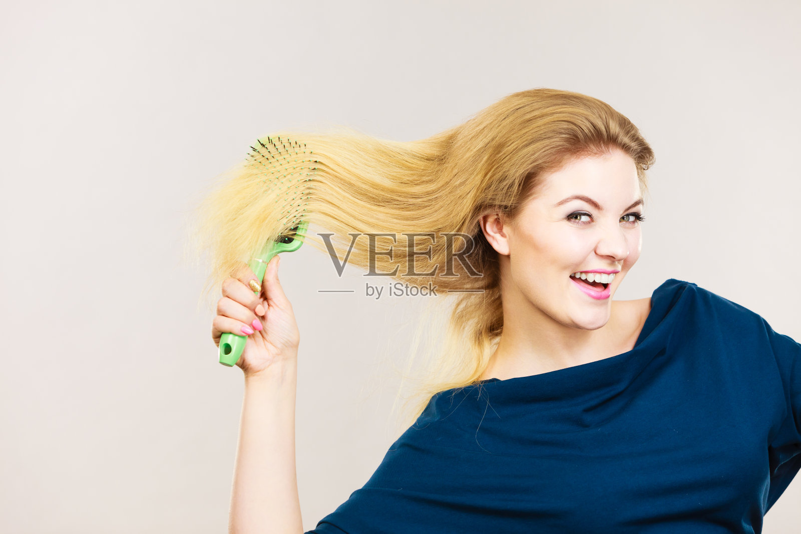 一个女人正在梳理她的金色长发照片摄影图片