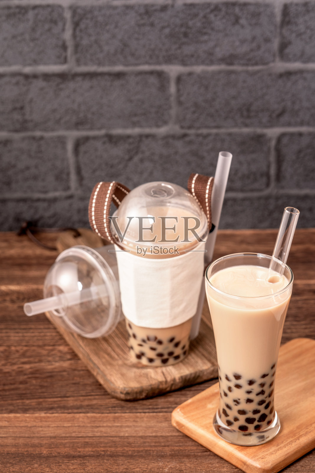 外卖用一次性物品概念流行台湾喝泡奶茶用塑料杯和吸管放在木桌背景上，近距离，拷贝空间照片摄影图片