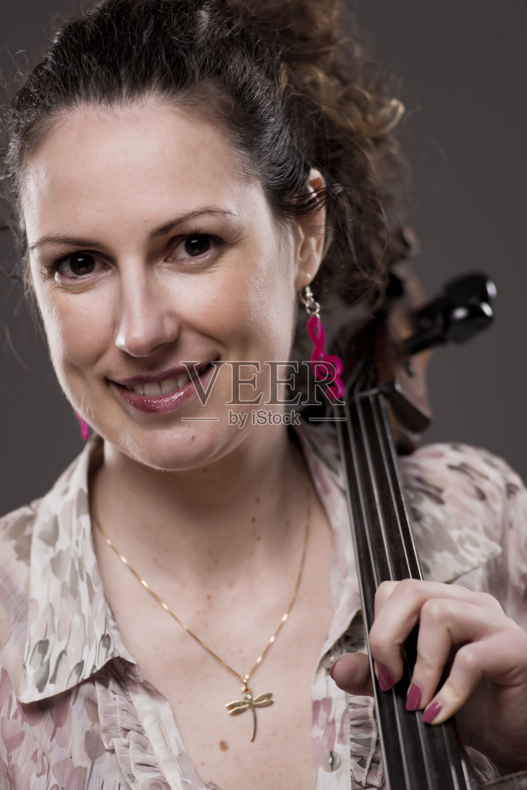 美丽的黑发女性大提琴家与她的乐器照片摄影图片