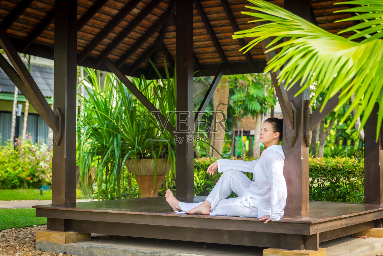 一名女子练完瑜伽后，穿着白色衣服坐在凉亭里照片摄影图片