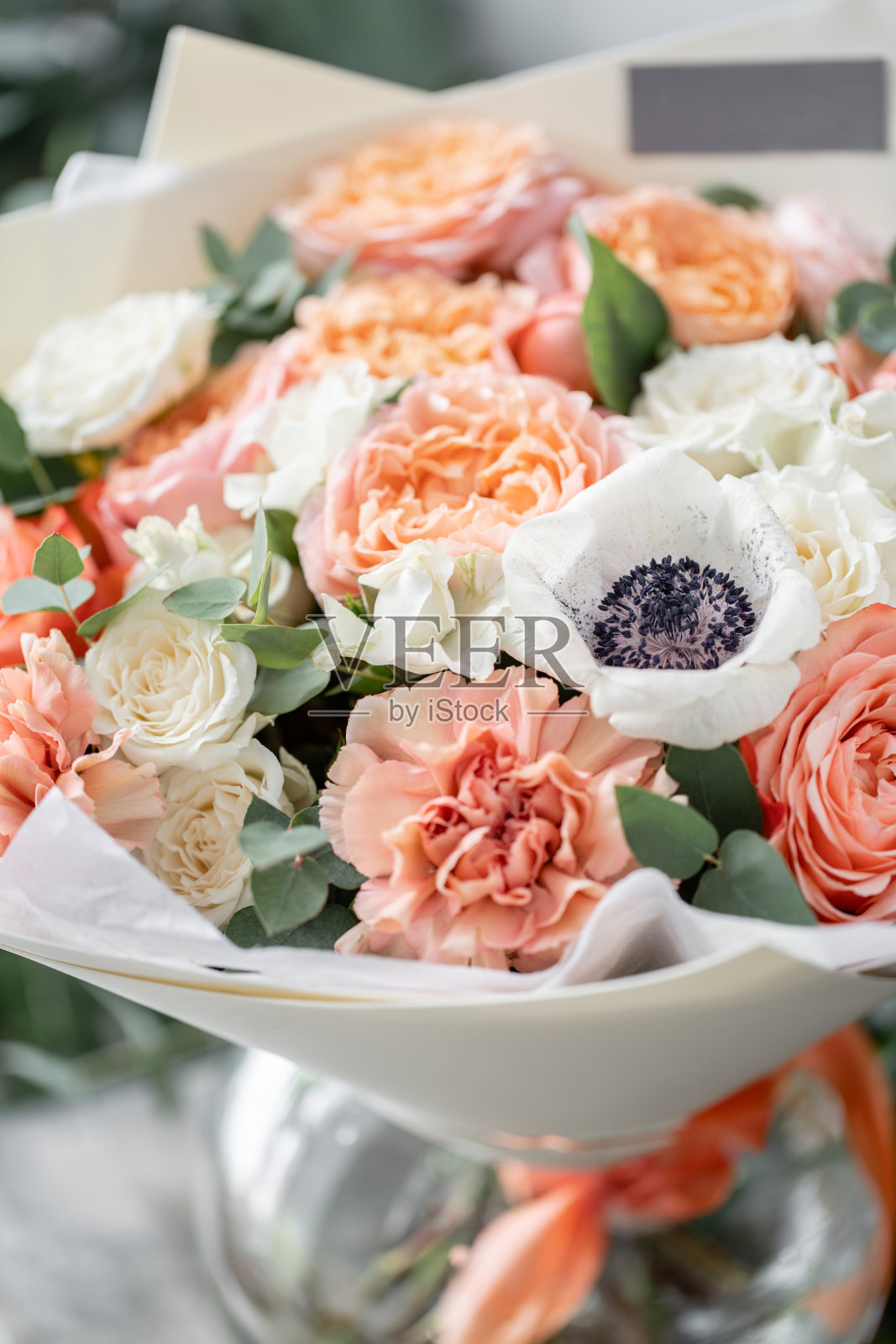 木桌上的花瓶里插着一束漂亮的鲜花。花店花匠的工作。柔和的色调颜色照片摄影图片