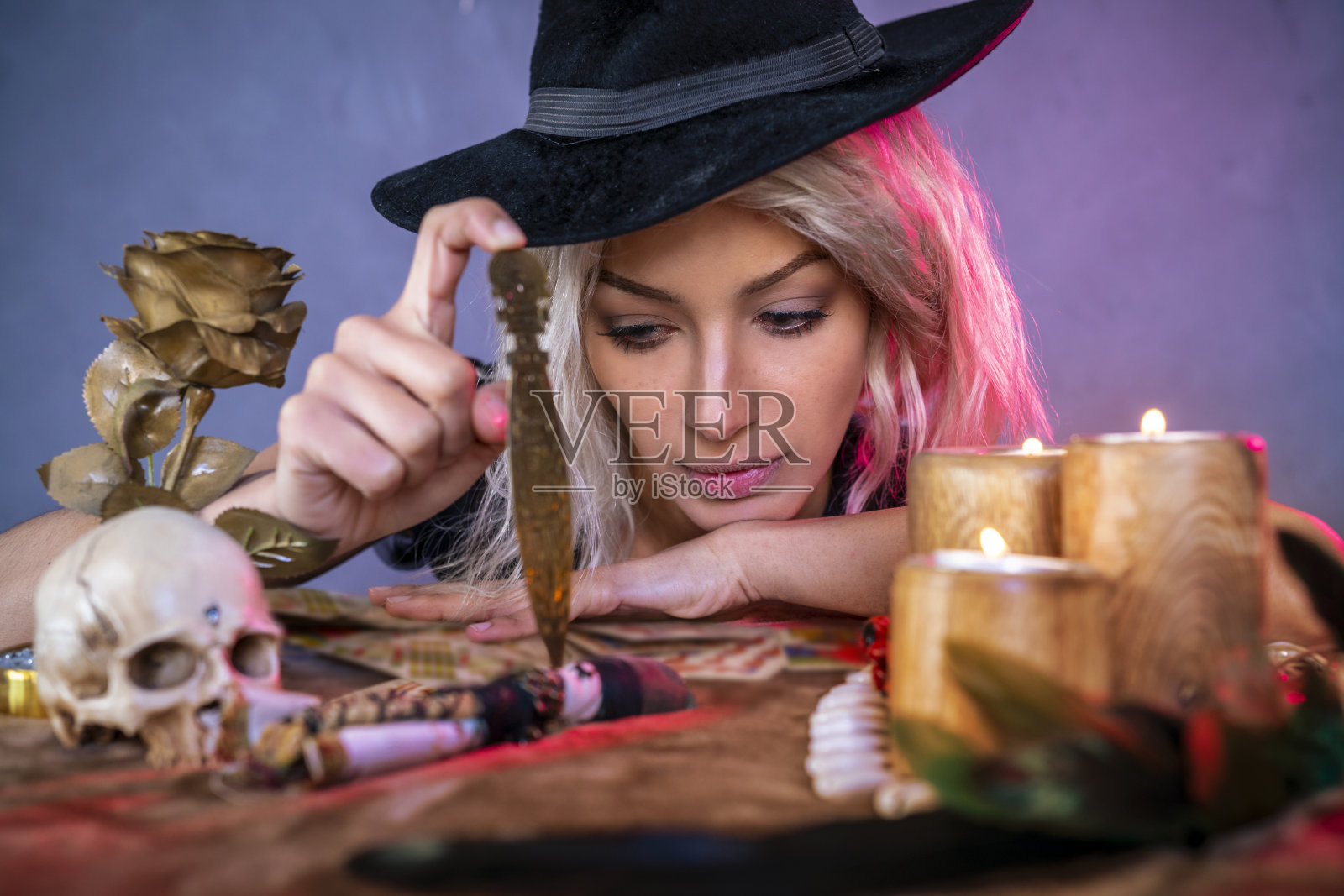 桌上放着刀和女巫帽的伏都教女孩照片摄影图片