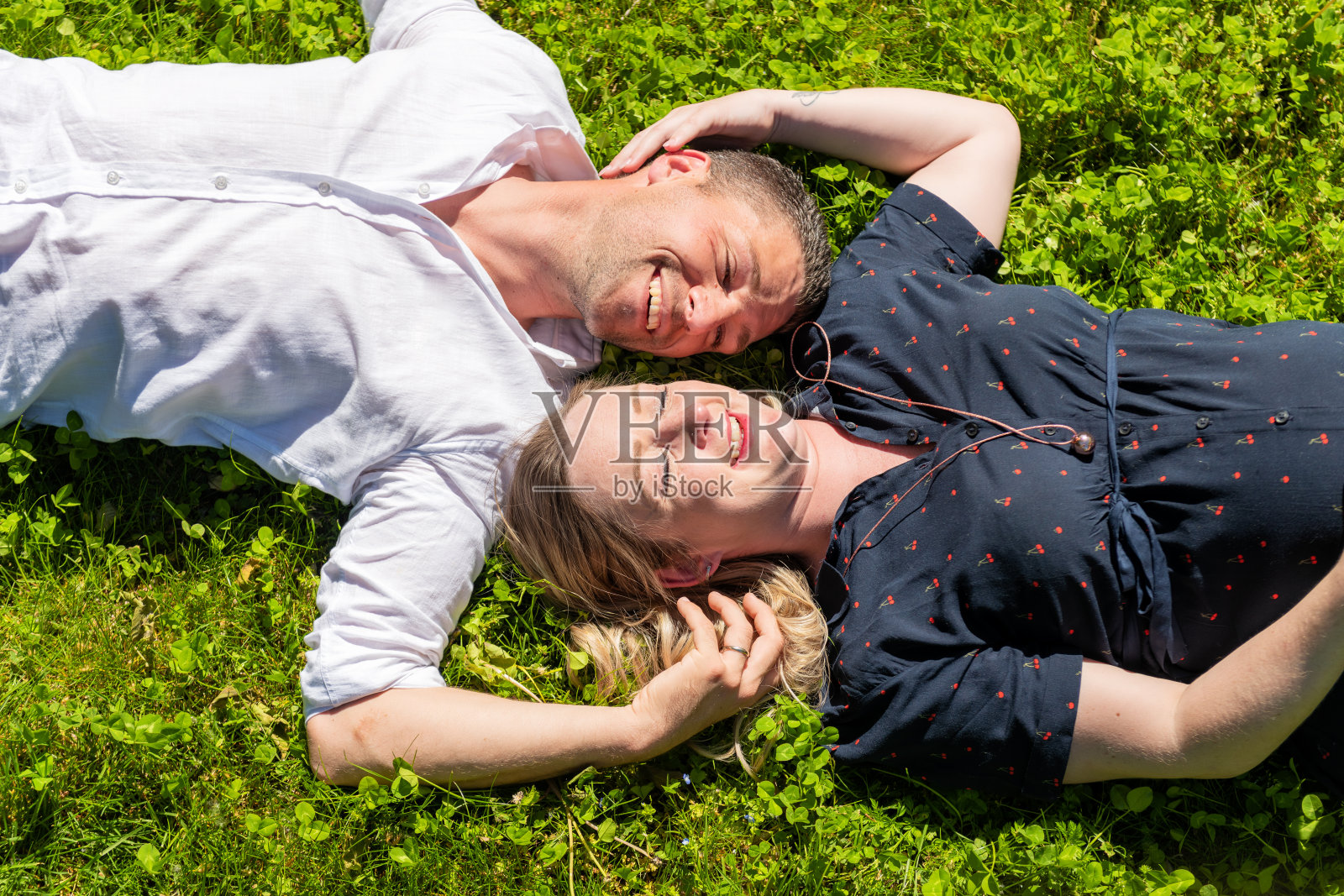 草地上一对有趣可爱的情侣照片摄影图片