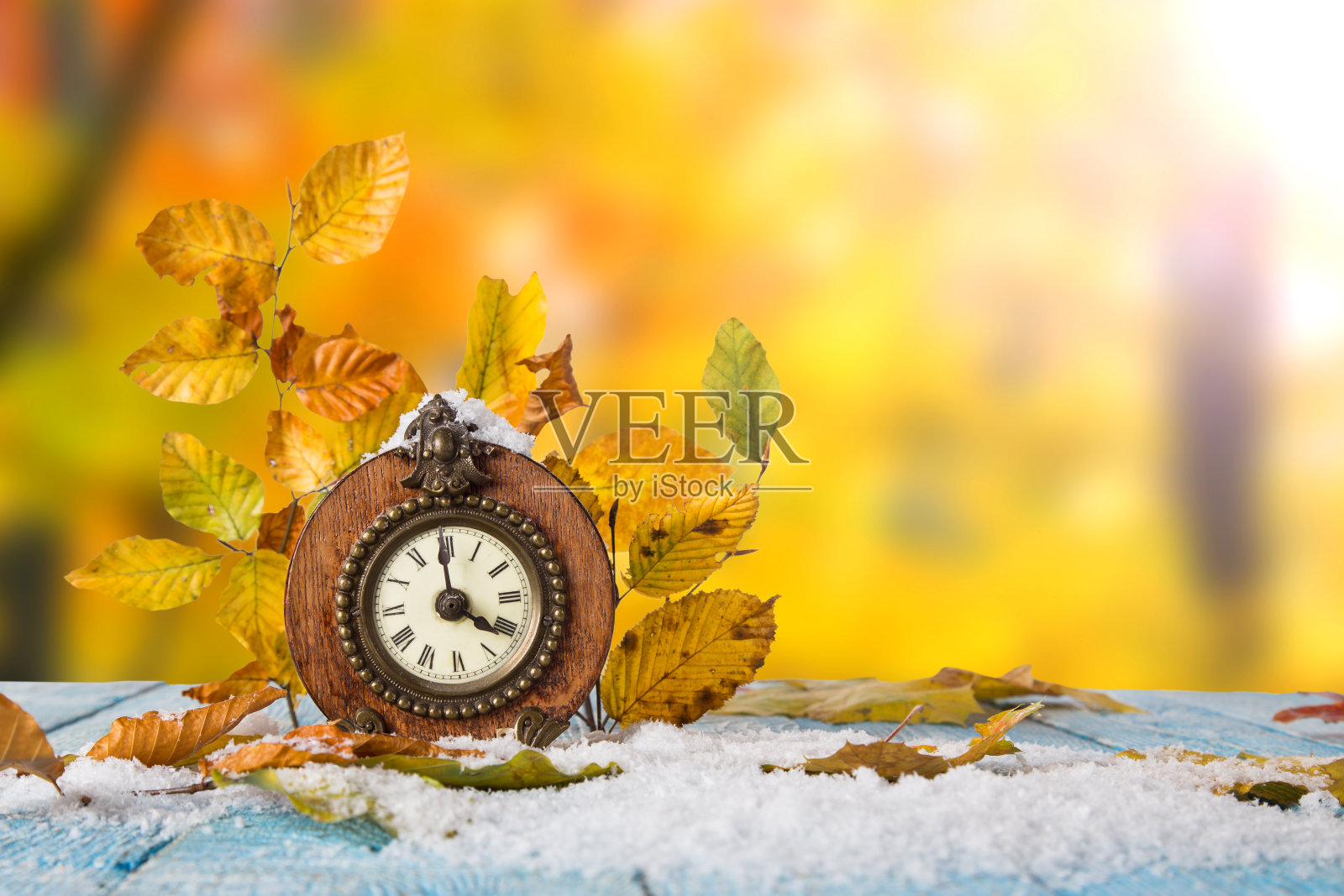 秋天的时间改变概念。枫叶和古董钟照片摄影图片