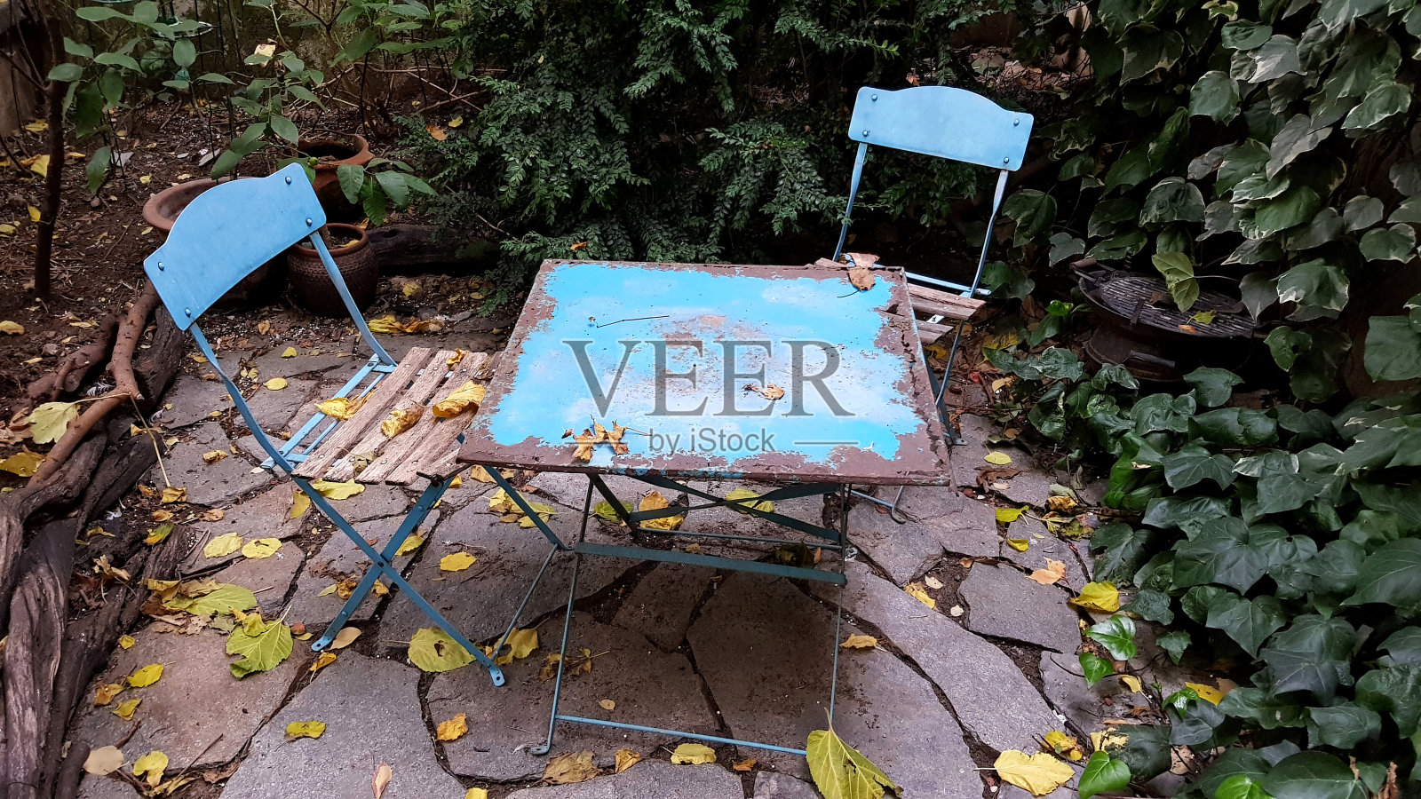 花园里生锈的桌子和椅子。照片摄影图片