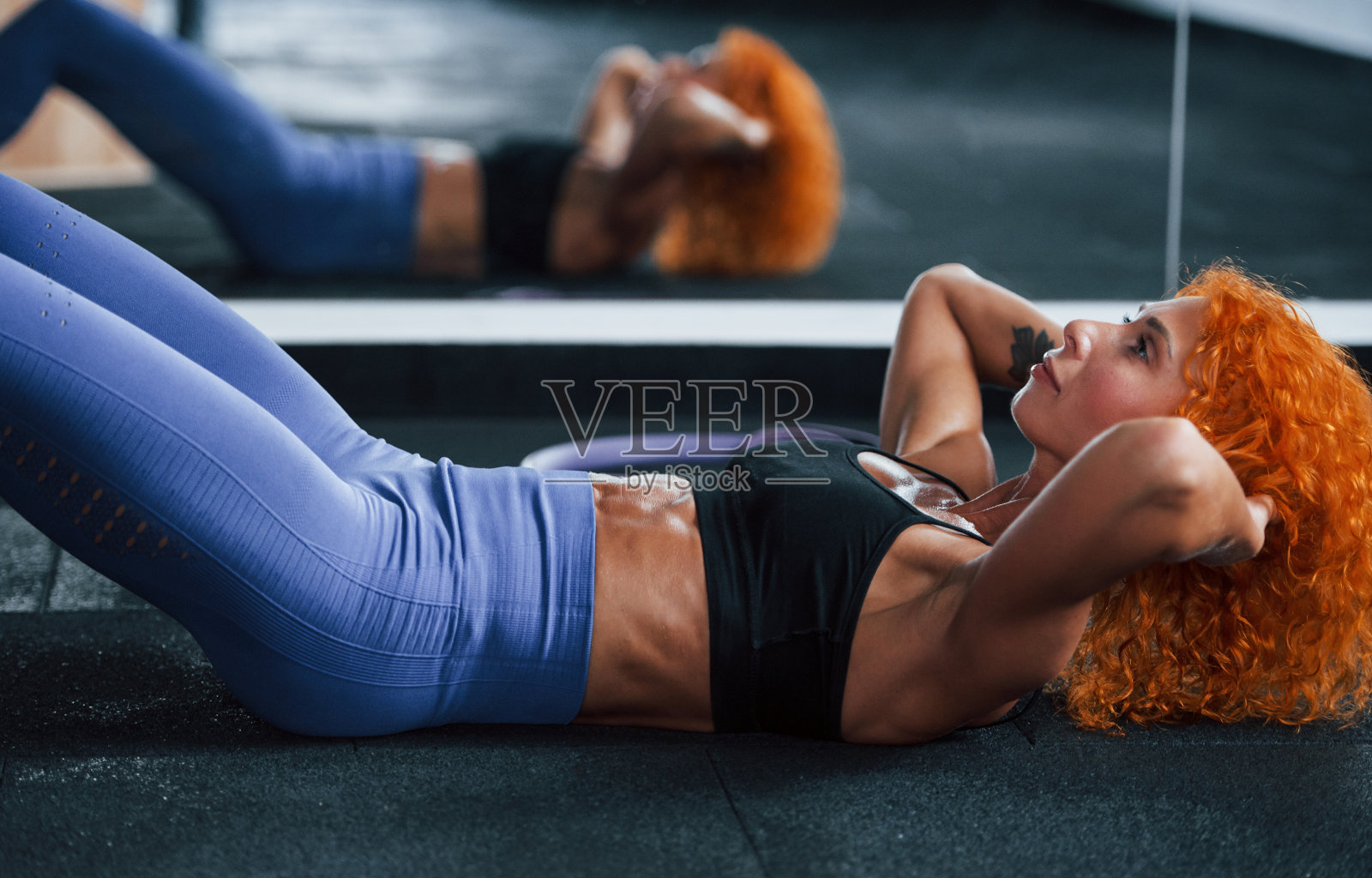 侧视图。喜欢运动的红发女孩白天去健身房健身。肌肉发达的身体类型照片摄影图片