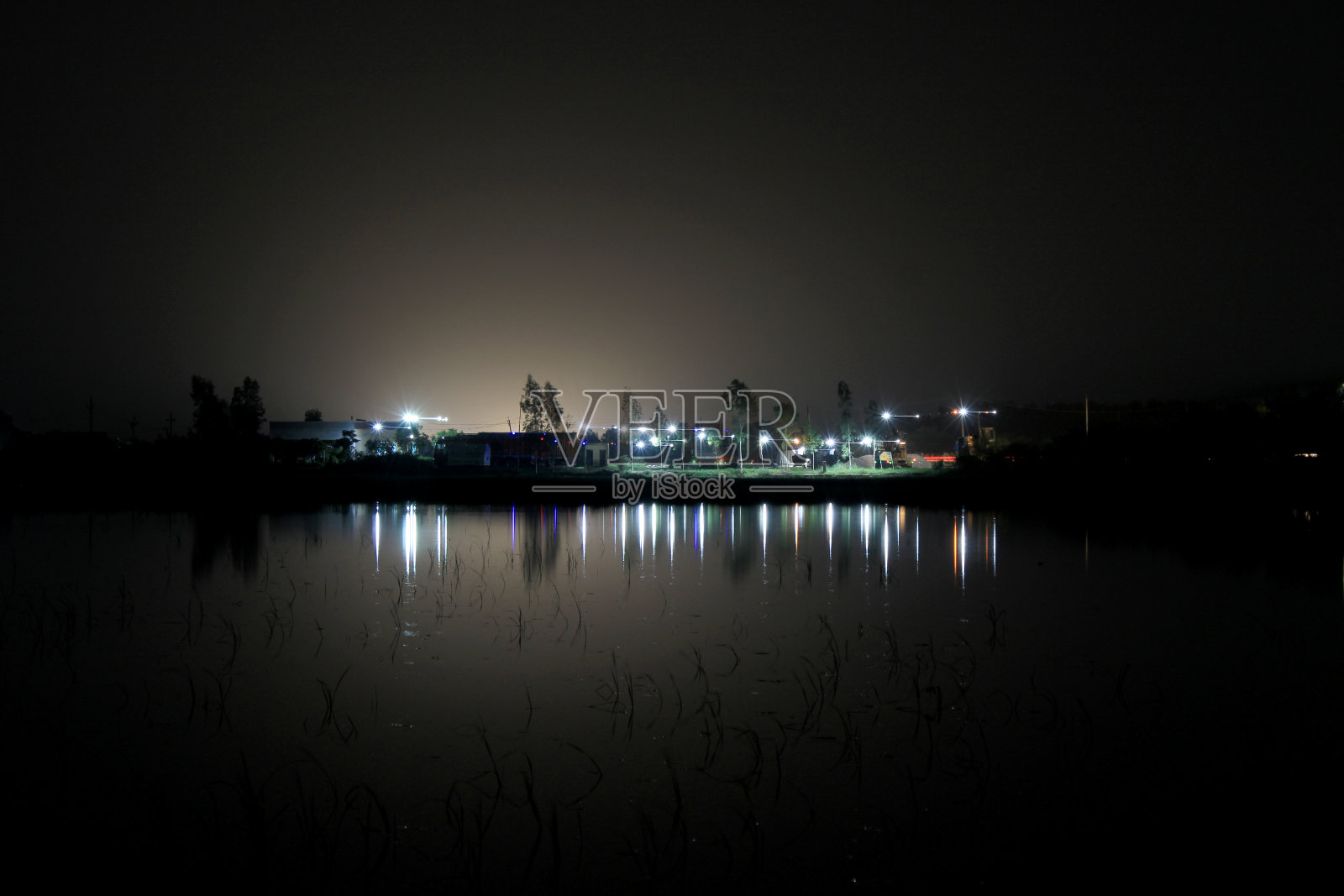 夜城附近的池塘照片摄影图片