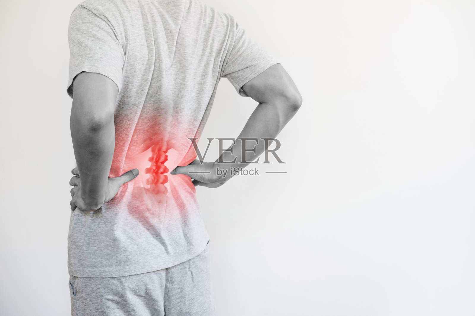 办公室综合征，背痛和下背痛的概念。一个男人在触碰他的下背部的痛点照片摄影图片