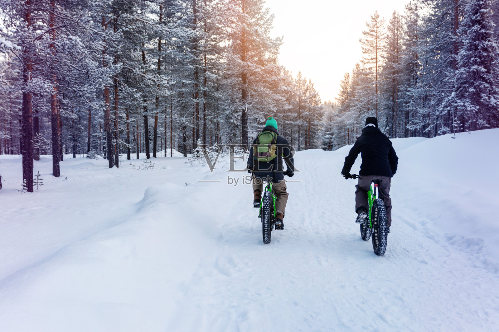 两个人在芬兰雪地里骑着胖胖的自行车照片摄影图片
