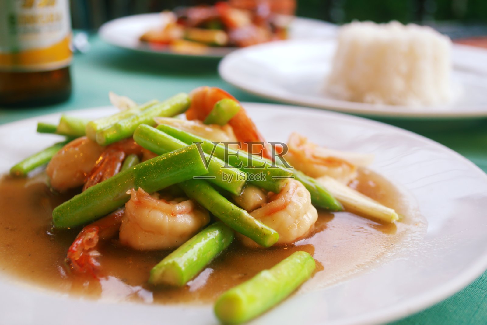 在泰国普吉岛的一家餐馆里，用糖醋汁腌制的虾仁和青豆，配上蒸饭。照片摄影图片