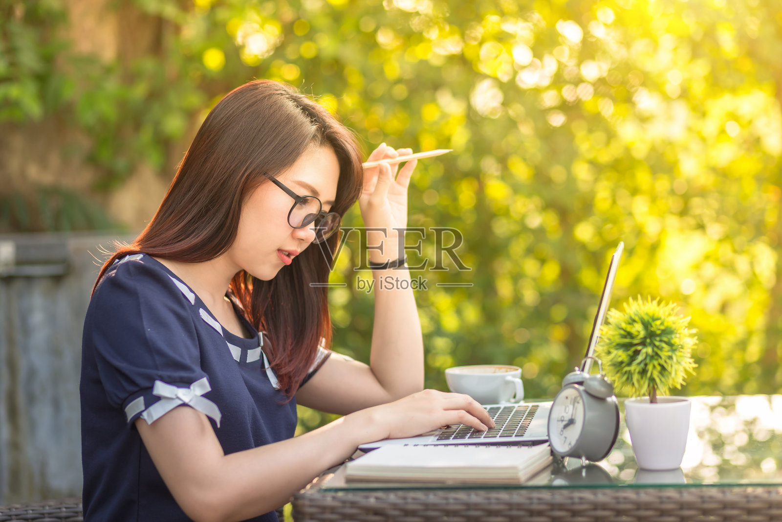 亚洲商务女性在户外办公室用笔记本电脑工作，想想工作。照片摄影图片