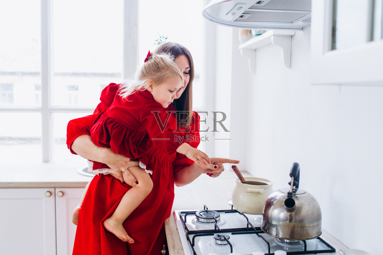 母亲和女儿在明亮的厨房里。朴素。快乐的宝宝和他的妈妈。照片摄影图片