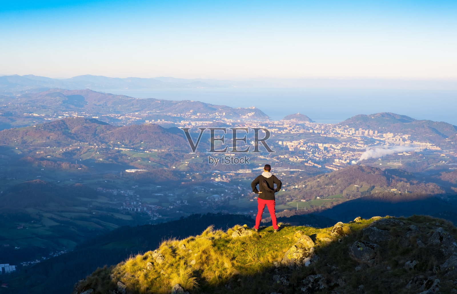 埃亚科哈里亚克山顶的登山者尤斯卡迪以多诺斯提亚市为背景照片摄影图片